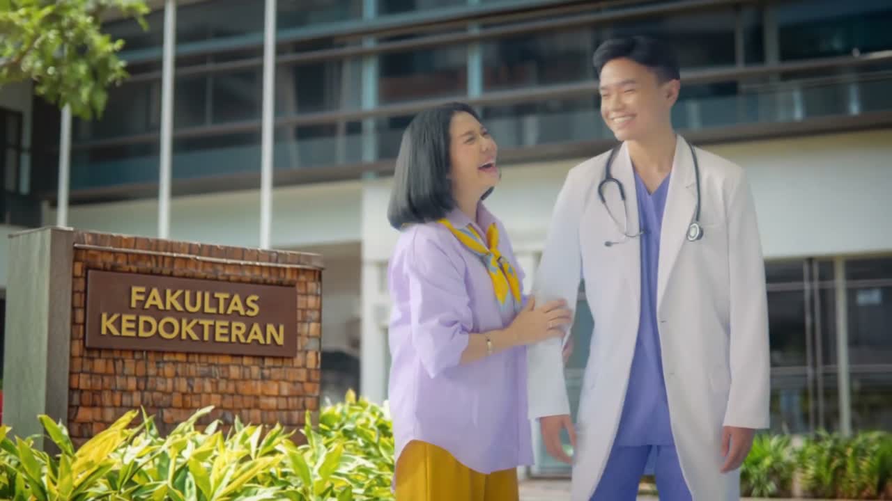 A mother shares a proud moment with her son, now a doctor, outside a medical school, from a Bank Mega savings campaign.